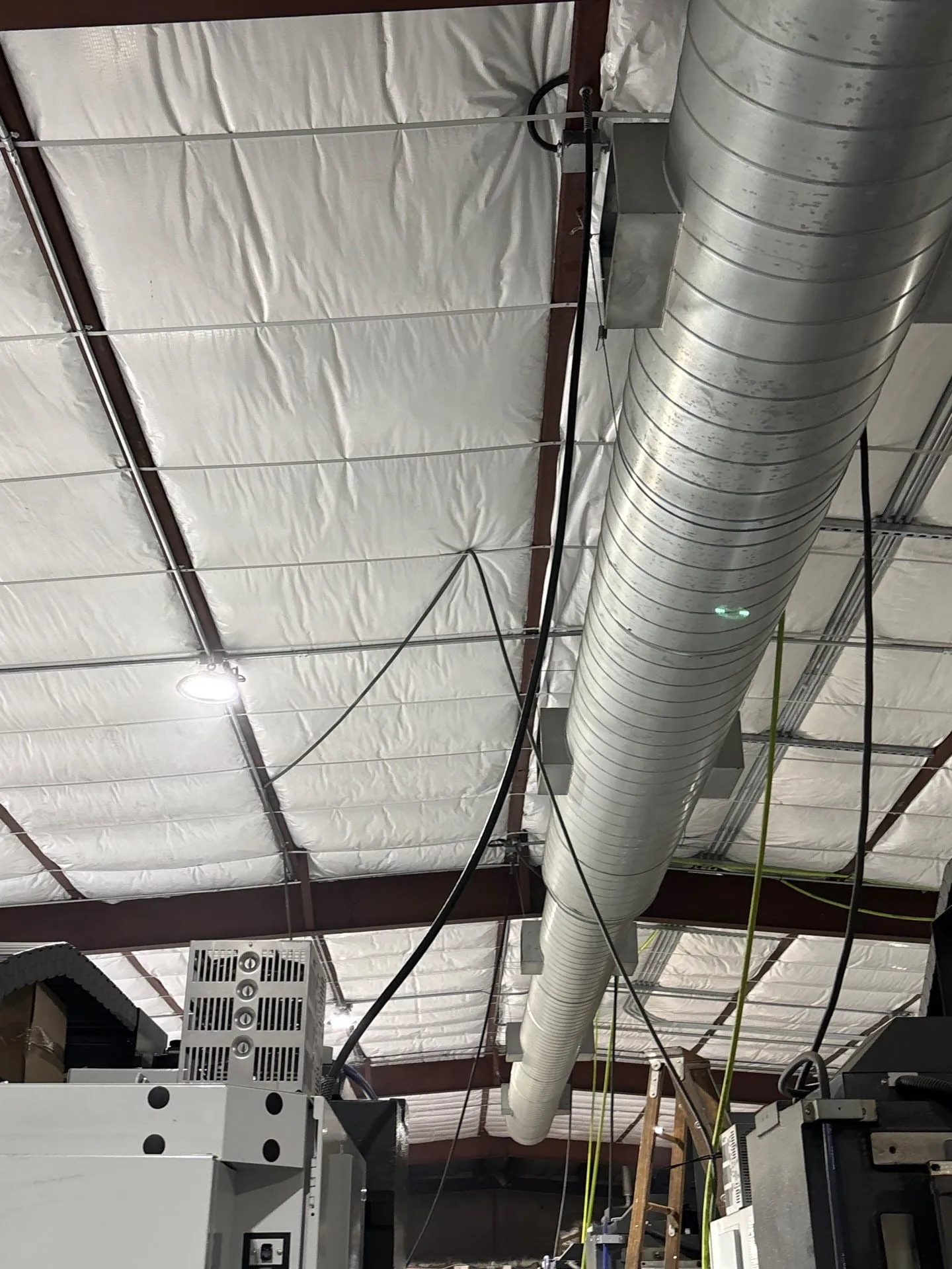 Spiral ductwork and conduit overhead in the shop