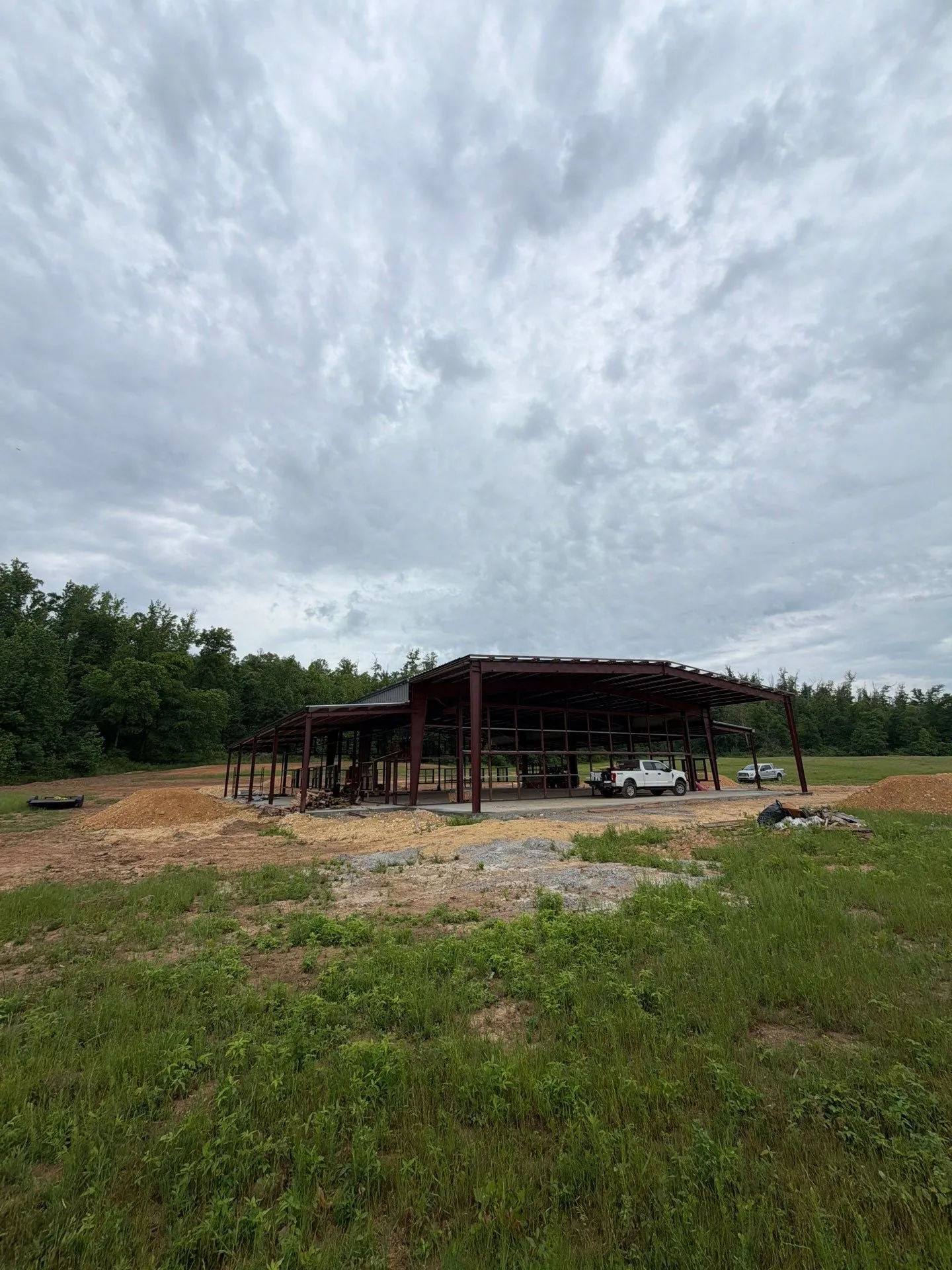 Hangar frame standing in an open field under dramatic clouds