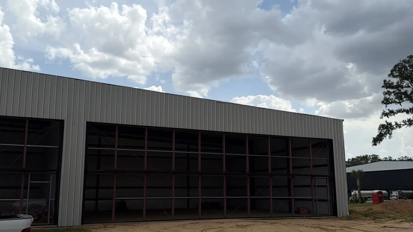 Open hydraulic door on a new steel hangar under a cloudy sky