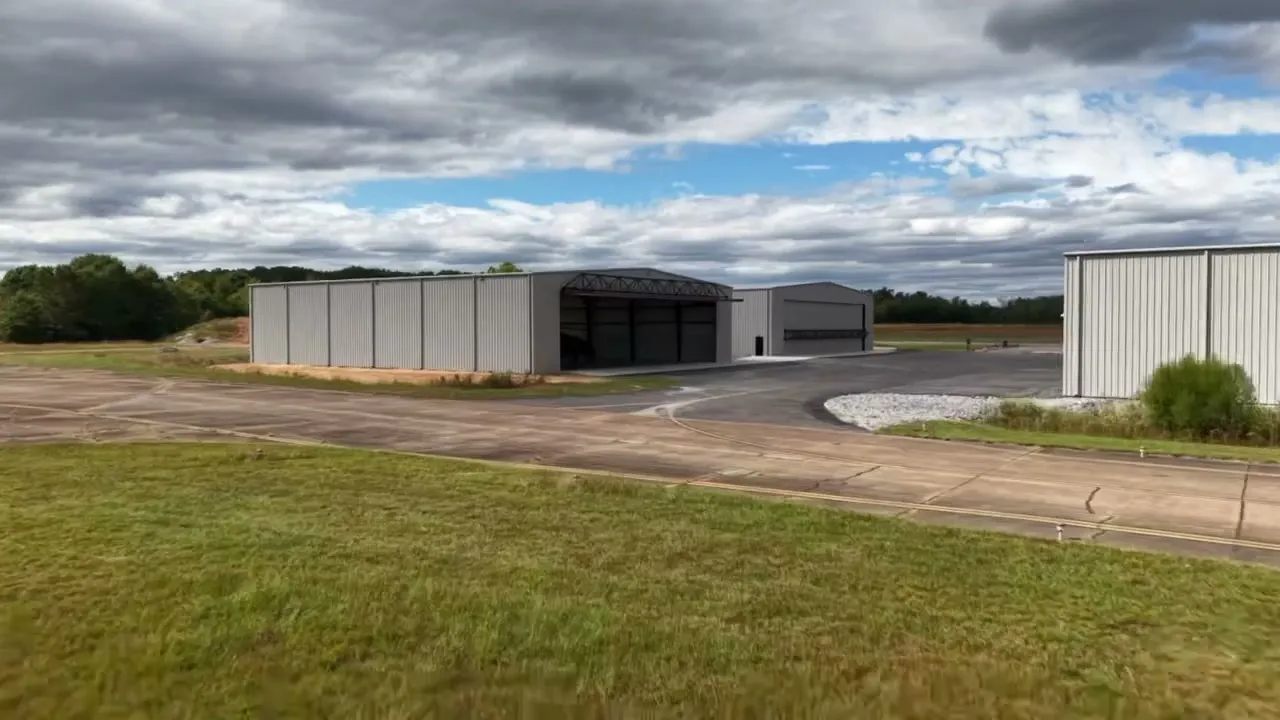 Two new white steel hangars with office windows facing a lawn at Jumbolair Aviation Estates