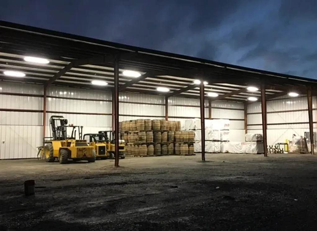 Interior of a large steel building at night with high-bay lighting on