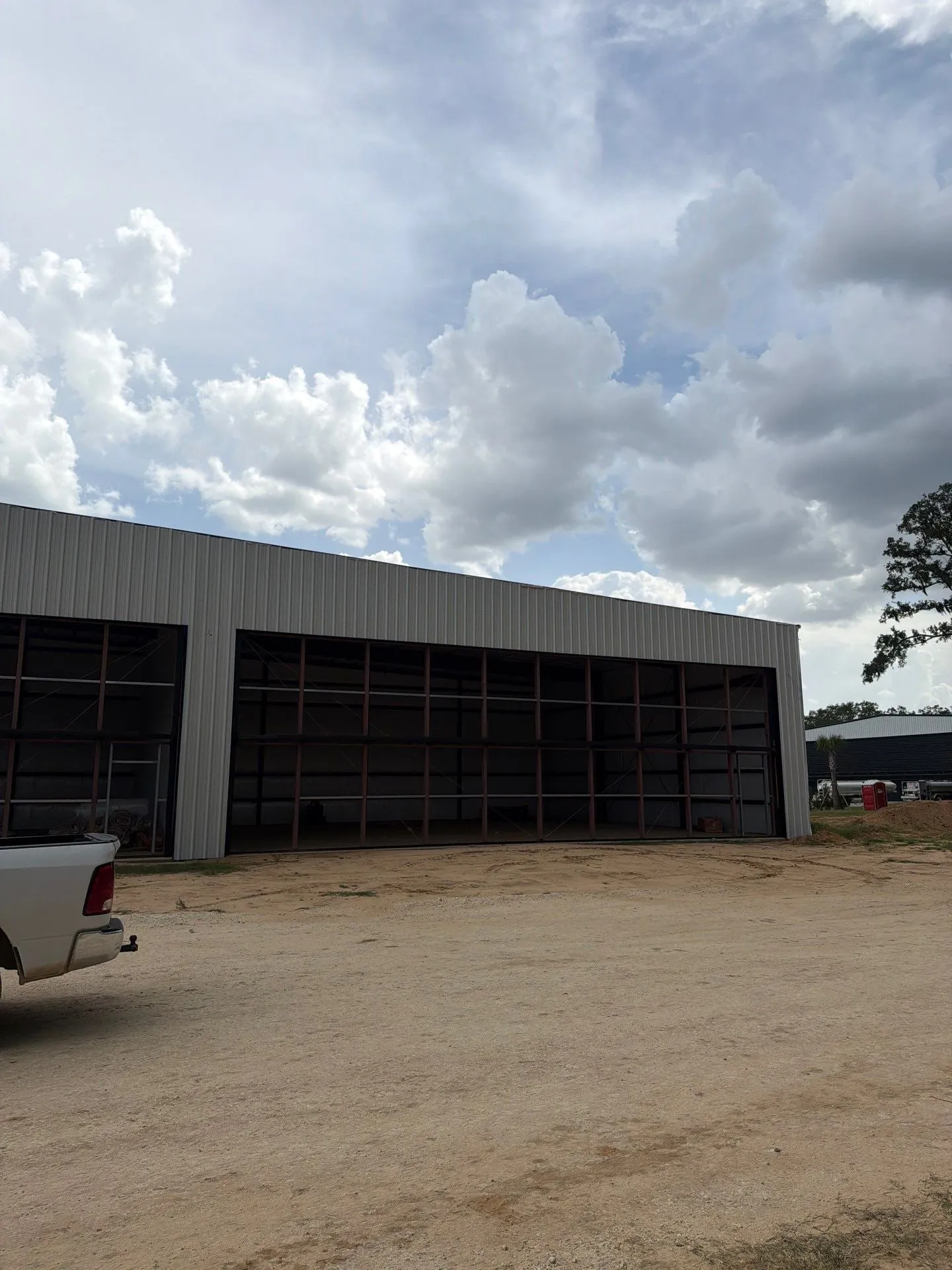 Row of hangars with hydraulic doors under a cloudy Florida sky