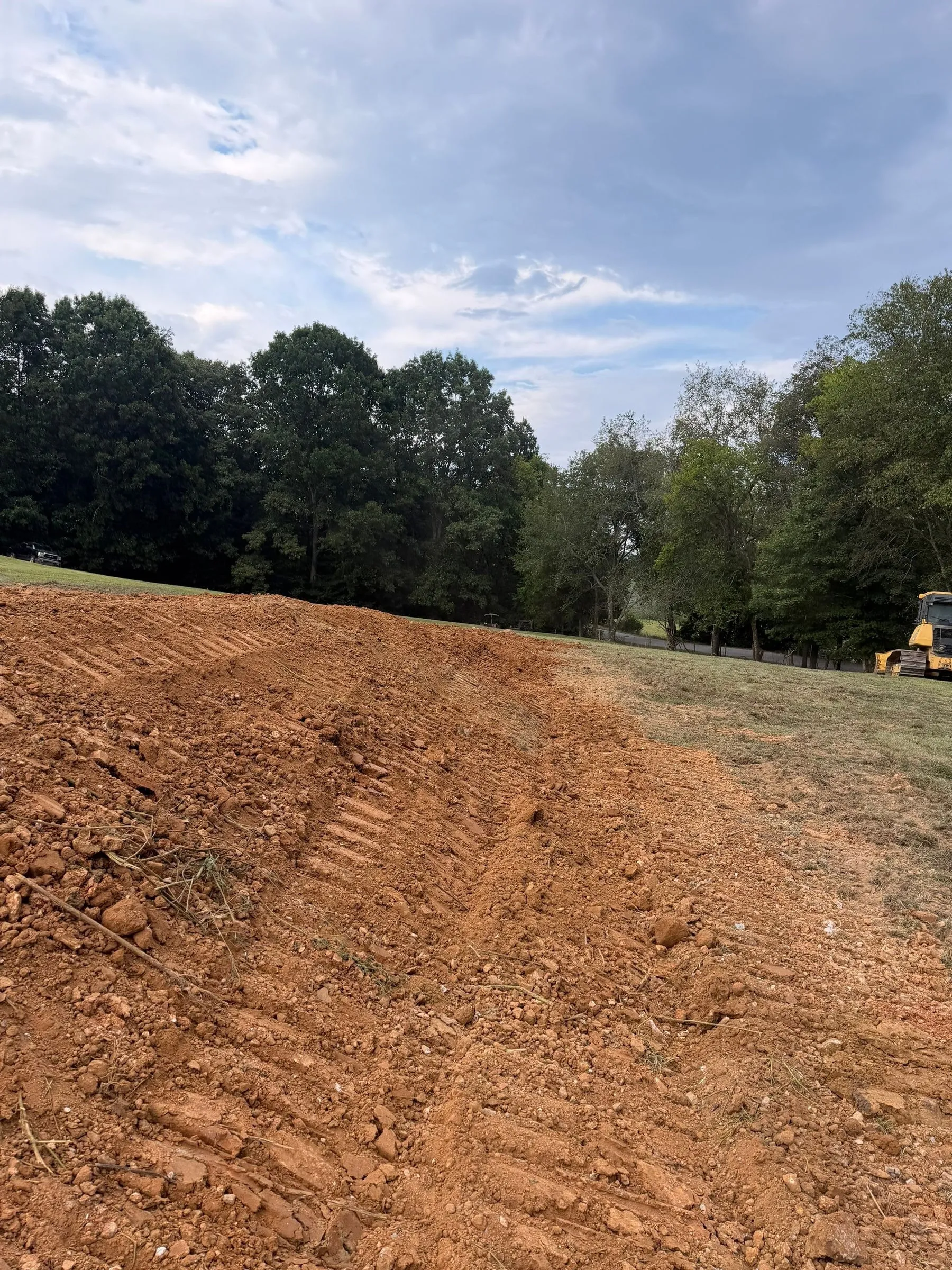 Stockpiled fill at the edge of the graded pad
