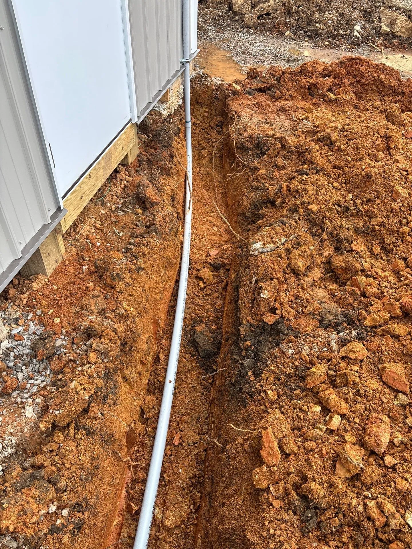 Underground conduit in a trench along the warehouse wall