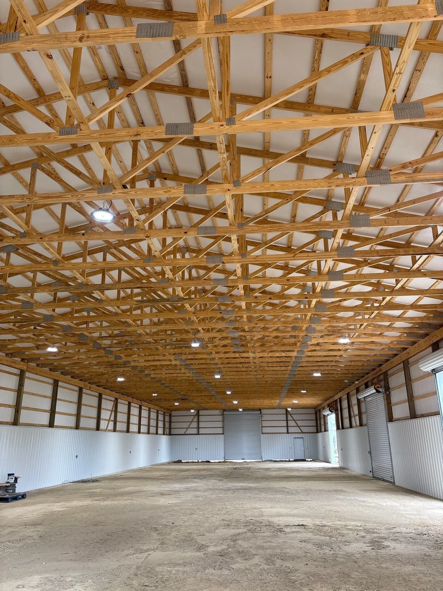Interior of a new warehouse with wood trusses and high-bay lights on